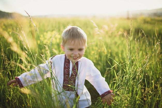 Passeio de sorriso da criança por um campo verde