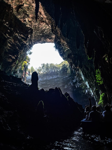 Passeio por turistas de barco em uma caverna com um lago subterrâneo Melissani na ilha de Cefalônia Grécia