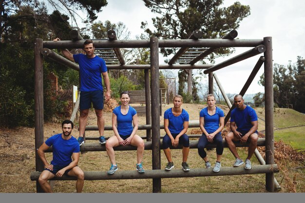 Passen Sie Leute an, die auf dem Hindernis im Bootcamp sitzen