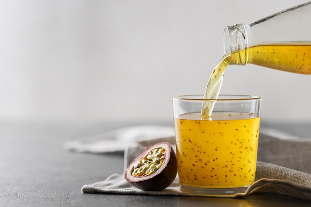 Passionsfruchtgetränk mit Chiasamen. Gießen Sie den Saft aus der Flasche in ein Glas.