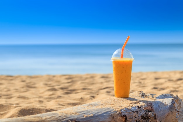 Passionsfruchtsaft mit Strohhalm im Glas am Sandstrand bei Phuket Thailand. Sommerkonzept