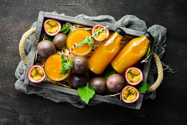 Passionsfruchtsaft und Früchte auf einem hölzernen Hintergrund Tropische Früchte