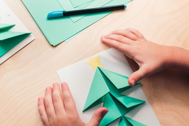 Foto passo 6 de fazer cartão de natal: cola de papel estrela no topo da árvore de natal