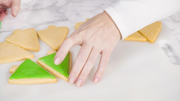 Passo a passo. Biscoitos de açúcar em forma de árvore de Natal de confeiteiro com glacê real verde.