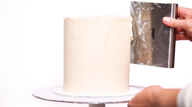 Passo a passo. bolo de aniversário alto de confeiteiro com glacê de creme de manteiga branco.