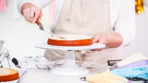 Foto passo a passo. chef de pastelaria fazendo bolo de unicórnio para festa de aniversário de menina.