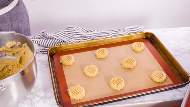 Passo a passo. Colher a massa de biscoitos de manteiga de amendoim com pá de massa na assadeira.