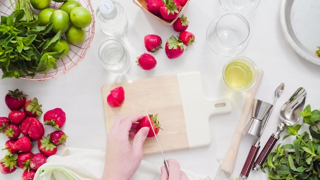 Passo a passo. Corte de frutas para mojito de morango de morangos orgânicos frescos.