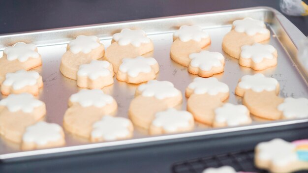 Passo a passo. Decorando biscoitos de açúcar de unicórnio com glacê real na assadeira.