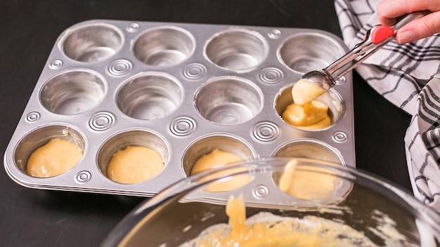 Passo a passo. Enchendo a forma de muffin de metal com massa de pão de milho.