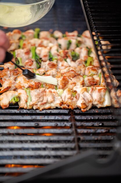 Passo a passo. Grelhar yakitori de frango em espetos de bambu na churrasqueira a gás ao ar livre.