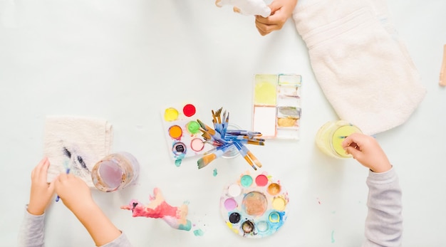 Passo a passo. Meninas pintando unicórnio de papel machê com tinta acrílica.