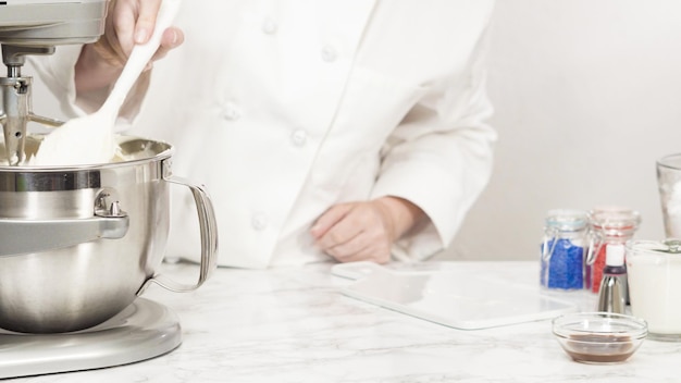 Passo a passo. Misturar os ingredientes na batedeira de cozinha em pé para fazer a cobertura de creme de manteiga.