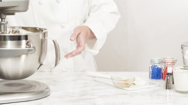 Passo a passo. Misturar os ingredientes na batedeira de cozinha em pé para fazer a cobertura de creme de manteiga.