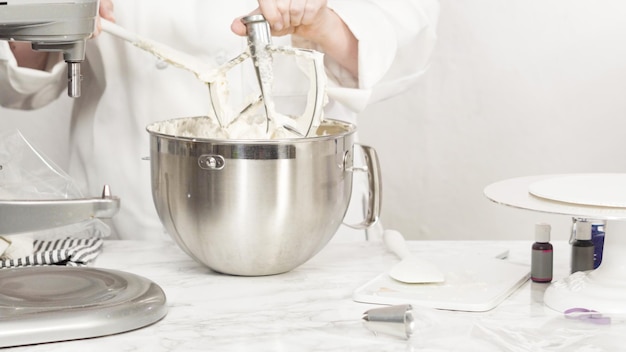 Passo a passo. Misturar os ingredientes na batedeira de cozinha em pé para fazer a cobertura de creme de manteiga.