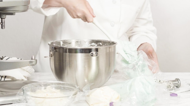 Passo a passo. Misturar os ingredientes na batedeira de cozinha em pé para fazer a cobertura de creme de manteiga.