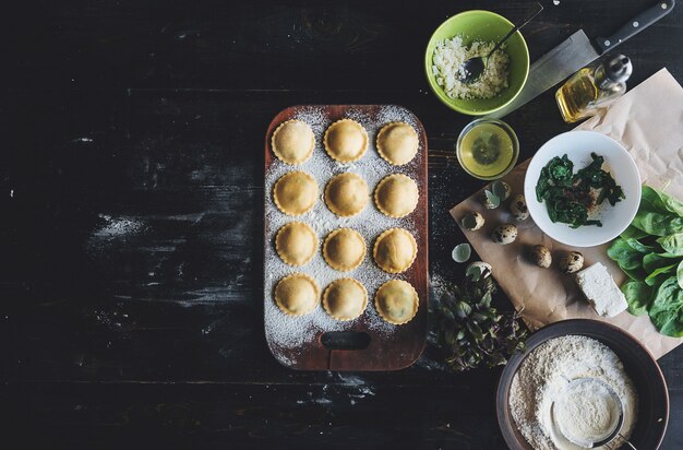 Passo a passo, o chef prepara ravioli com queijo ricota, gemas de ovos de codorna e espinafre com especiarias. O chef prepara-se para cozinhar ravioli