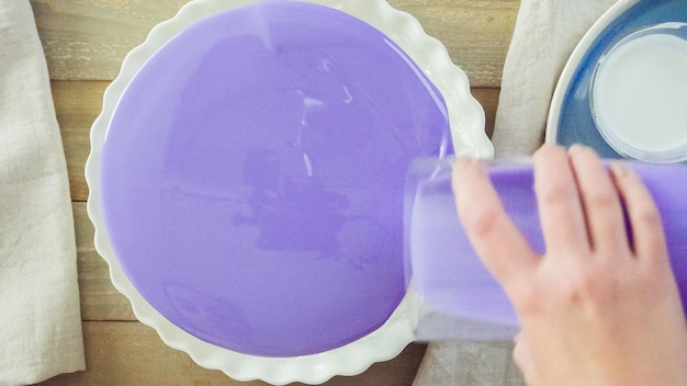 Passo a passo. Pastre shef fazendo bolo de mousse com esmalte roxo espelho e decorado com flores rosa chocolate.