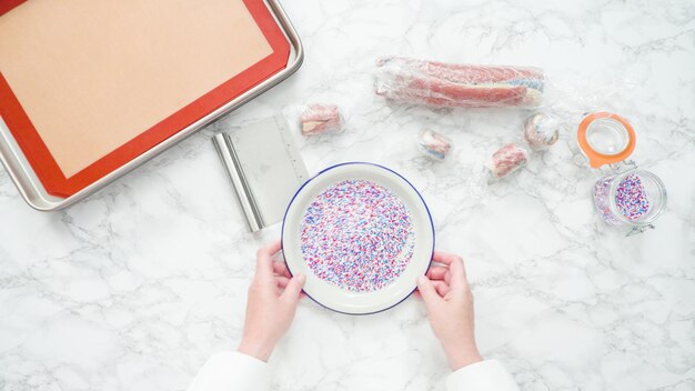 Passo a passo. Postura plana. Cortar a massa com uma faca de massa para assar biscoitos de açúcar de cata-vento vermelho, branco e azul.