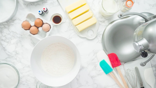 Passo a passo. Postura plana. Misturar ingredientes na batedeira de cozinha em pé para assar um bolo de baunilha de três camadas.