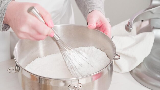 Passo a passo. Postura plana. Misturar o glacê real para decorar os bolinhos de açúcar da Páscoa.