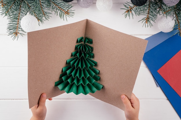 Passo a passo tutorial da árvore de natal em 3d para cartões de felicitações. etapa 19: abra o cartão postal e corrija se o papel foi movido para algum lugar. vista do topo