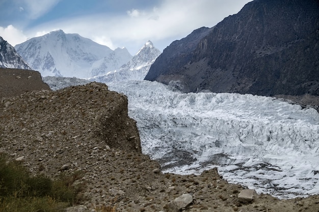 Foto passu-gletscher gegen schnee mit einer kappe bedeckte berge in karakoram-strecke