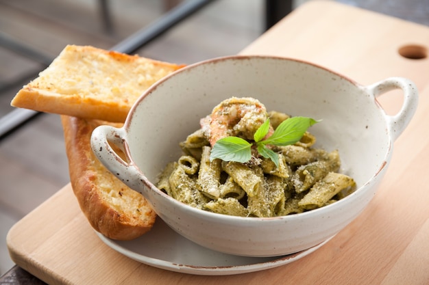 Pasta al pesto penne con camarones y pan de ajo