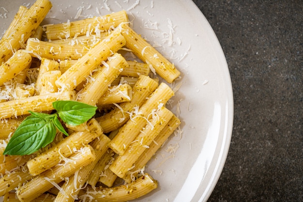 pasta al pesto rigatoni con queso parmesano - comida italiana y estilo vegetariano