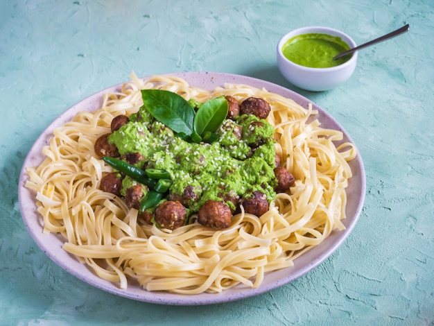 Pasta con albóndigas y salsa de espinacas. Vista superior.