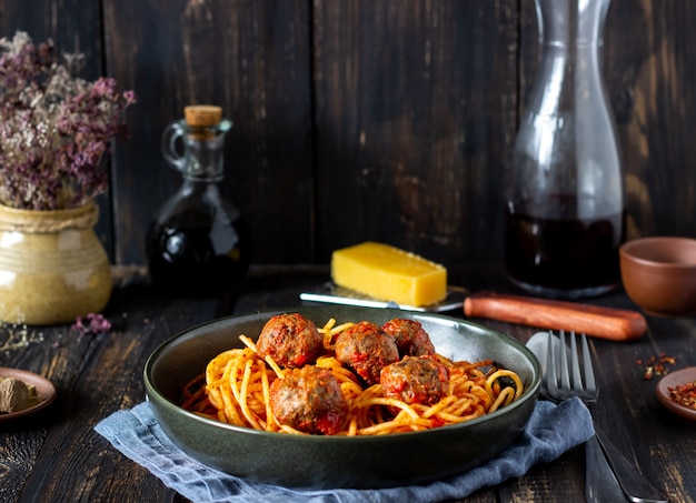 Pasta con albóndigas y salsa de tomate sobre un fondo de madera.