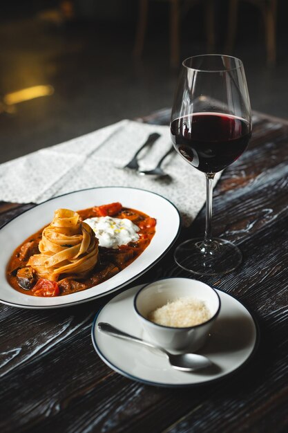 Pasta apetitosa con salsa de tomate y queso en una mesa de madera oscura Servicio de comida del restaurante