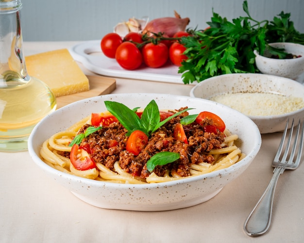 Foto pasta boloñesa con salsa de tomate, carne molida picada, hojas de albahaca