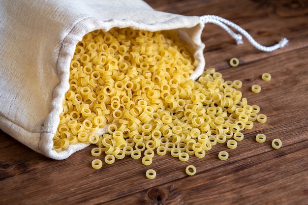 Pasta en una bolsa textil reutilizable sobre una mesa de madera