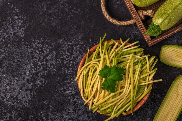 Pasta de calabacín cruda sobre superficie oscura