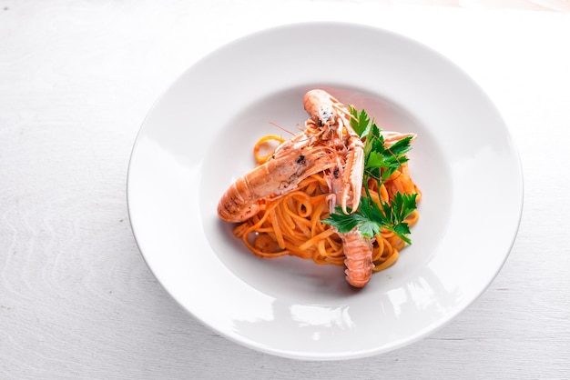 Pasta y camarones tigre en salsa de tomate Comida tradicional italiana Sobre un fondo de madera Vista superior Espacio libre para el texto