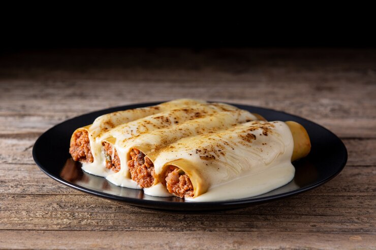 Pasta de canelones de carne deliciosa sobre mesa de madera rústica