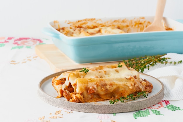 Pasta de canelones con relleno de carne molida, tomates, al horno con salsa de tomate bechamel