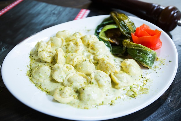 Pasta cappelletti rellena de carne cocinada con salsa y champiñones.