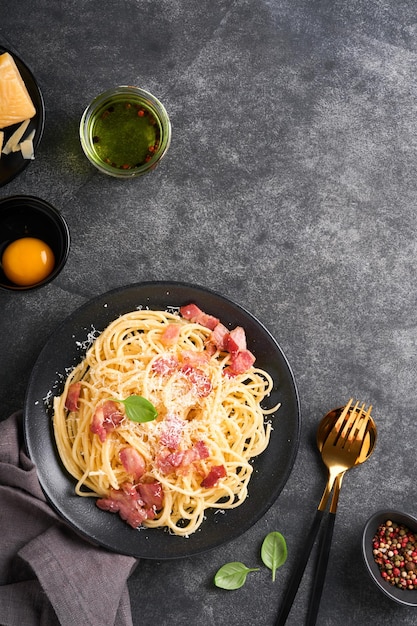 Pasta carbonara Espaguetis con panceta huevo queso parmesano y salsa de crema sobre fondo de mesa de hormigón negro oscuro Cocina tradicional italiana y plato Pasta alla carbonara Vista superior