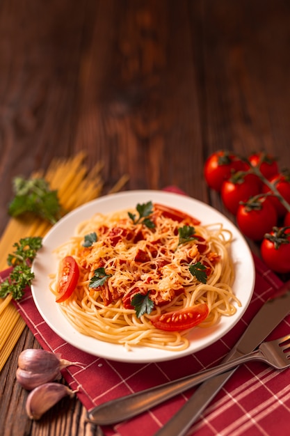 Pasta a la carbonara con salsa de tomate y carne picada, queso parmesano rallado y perejil fresco