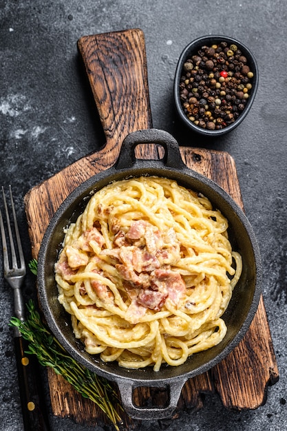 Pasta carbonara con tocino y parmesano en una sartén. vista superior.