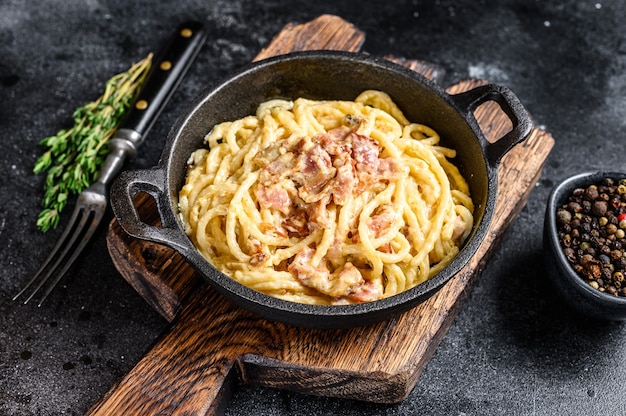 Pasta carbonara con tocino y parmesano en una sartén