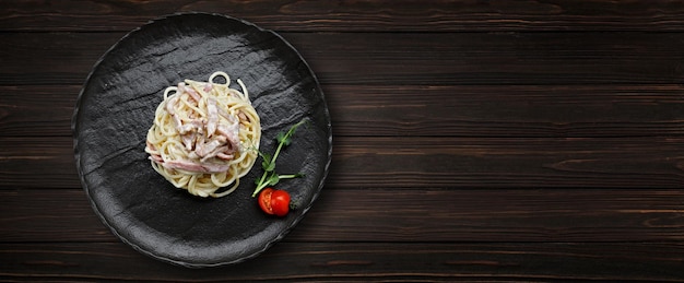 Pasta Carbonara con tomates sobre un fondo de madera