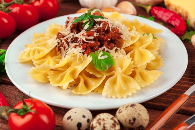 Pasta con carne, salsa de tomate y verduras sobre la mesa