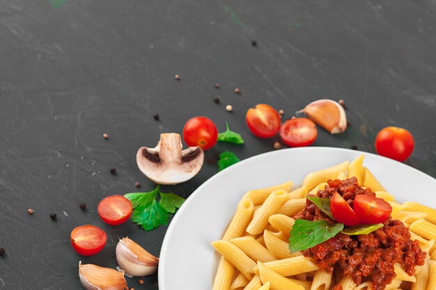 Pasta con carne, salsa de tomate y verduras sobre la mesa