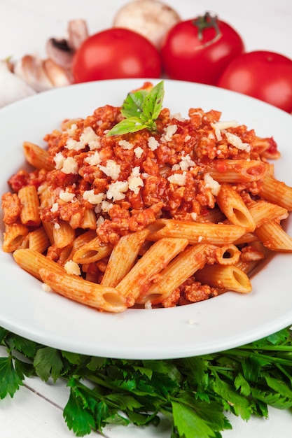 Pasta con carne, salsa de tomate y verduras sobre la mesa