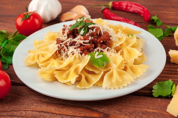 Pasta con carne, salsa de tomate y verduras sobre la mesa