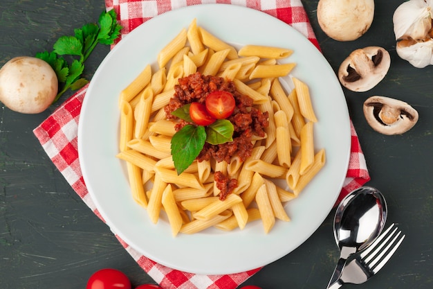 Pasta con carne, salsa de tomate y verduras sobre la mesa