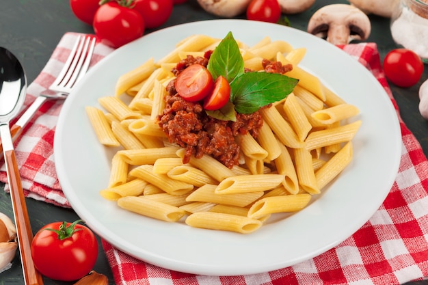 Pasta con carne, salsa de tomate y verduras sobre la mesa